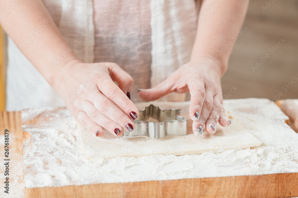 Culinary master class. Woman using star shaped cutter on dough to show how to make cookie. Pastry baking course.