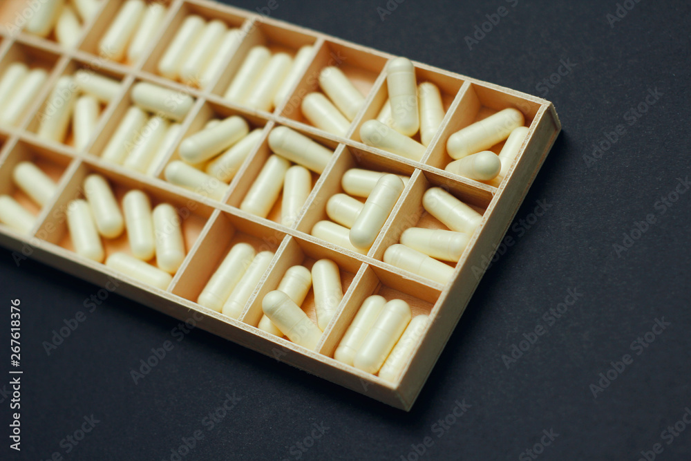 Yellow capsules pills in pillbox. Daily dose of medication. Weekly dosage. Yellow capsules pills in pillbox. Daily dose of medication. Weekly dosage.