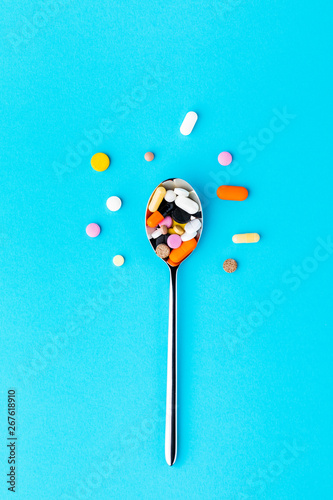 Pharmaceutical medicine tablets, tablets and capsules on an iron spoon. the concept of health