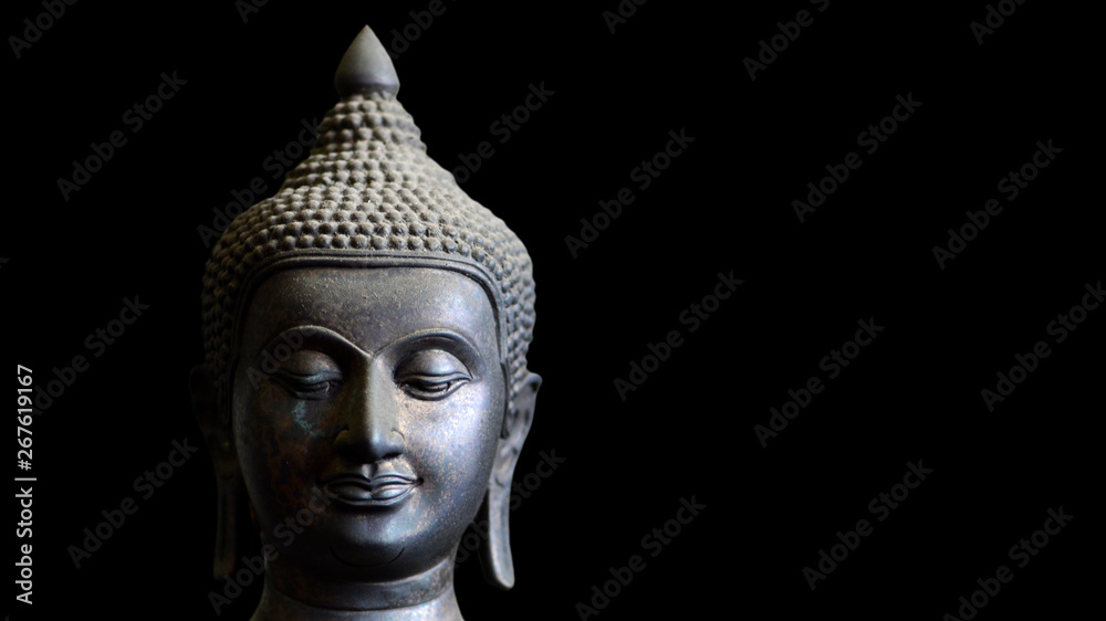 Buddha statue face closeup isolated on black