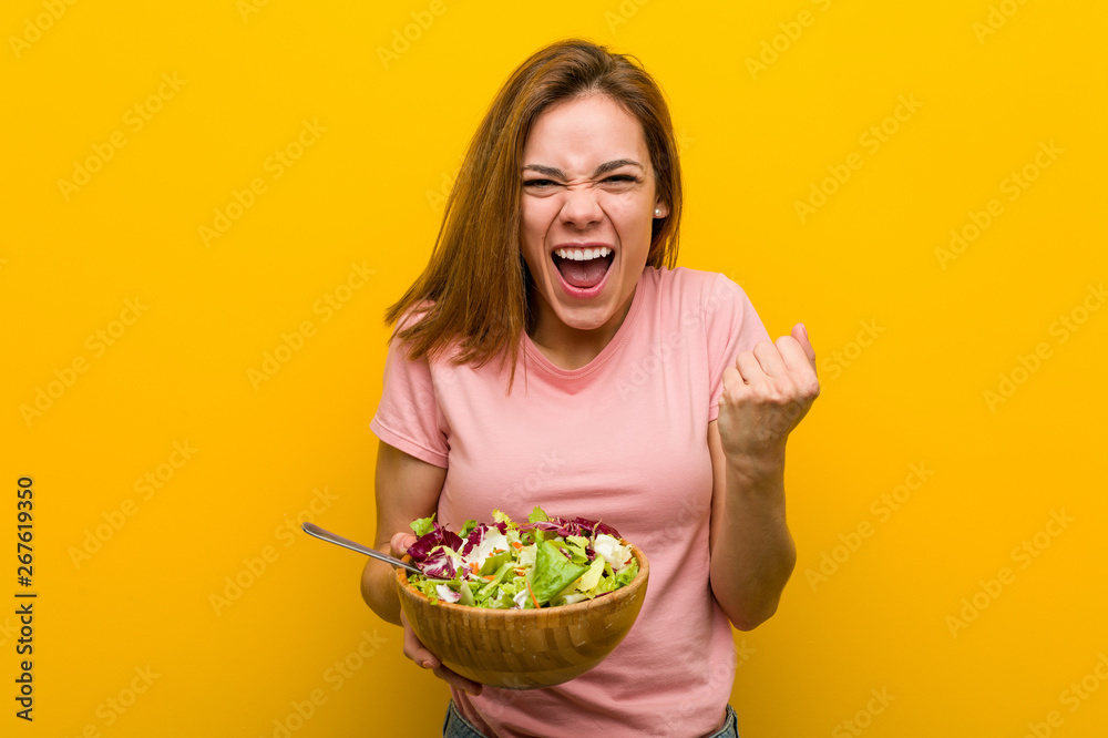 Young healthy woman holding a salad cheering carefree and excited. Victory concept. Young healthy woman holding a salad cheering carefree and excited. Victory concept.