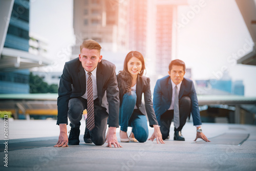 Business team ready to run at start point on blurred city background. Business success concept