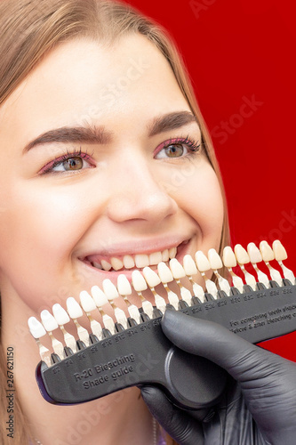 teeth whitening procedure dentist selects the initial shade of the girl's teeth bleaching shade guide