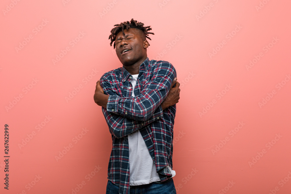 Young african black man hugs himself, smiling carefree and happy. Young african black man hugs himself, smiling carefree and happy.