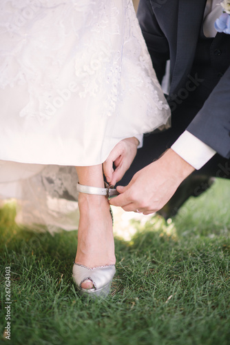 The groom puts the bride on the foot close-up shoe