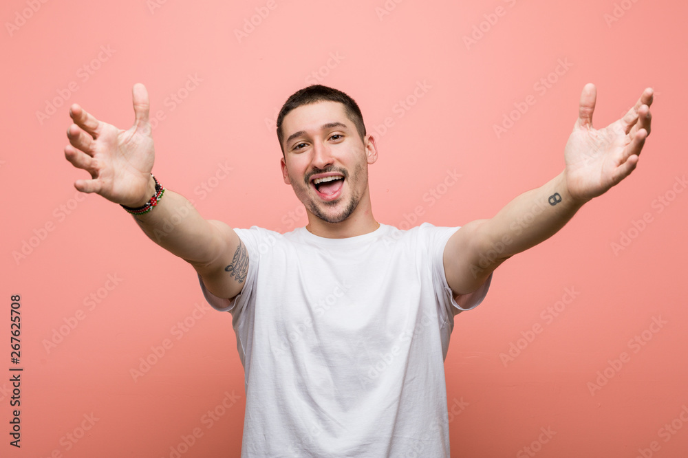 Young casual man feels confident giving a hug to the camera.