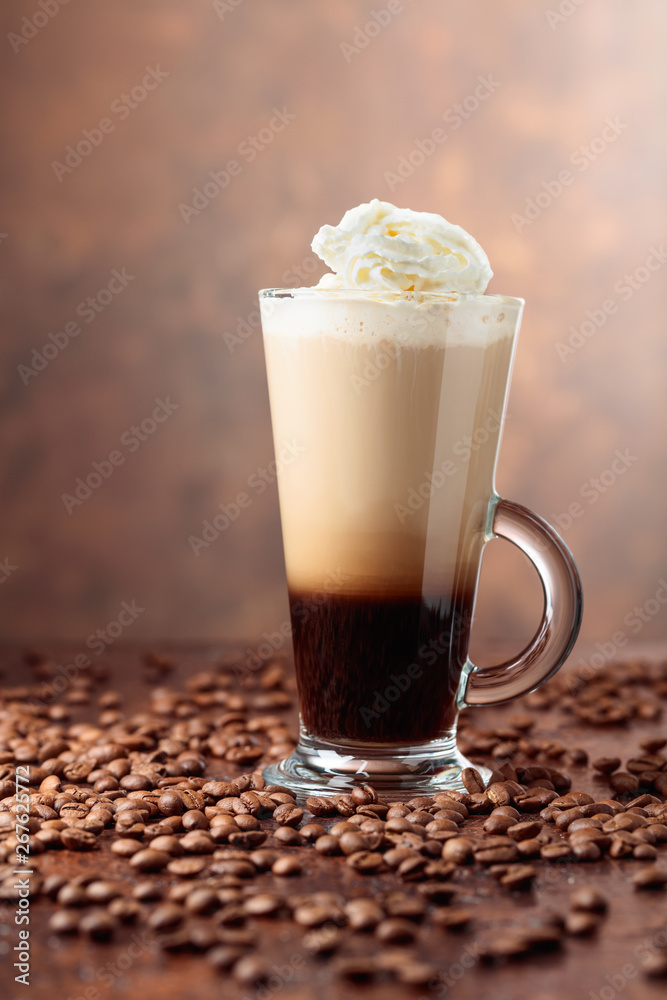 Glass cup with coffee and coffee beans on a brown background. Glass cup with coffee and coffee beans on a brown background.