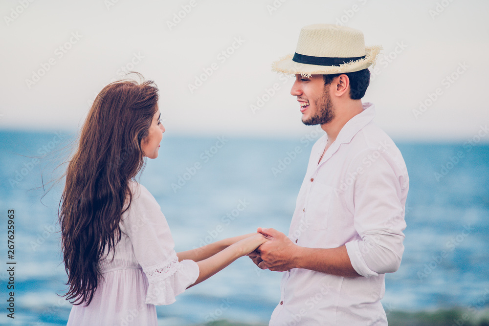 Happy Romantic Couples lover holding hands together walking on the beach Happy Romantic Couples lover holding hands together walking on the beach