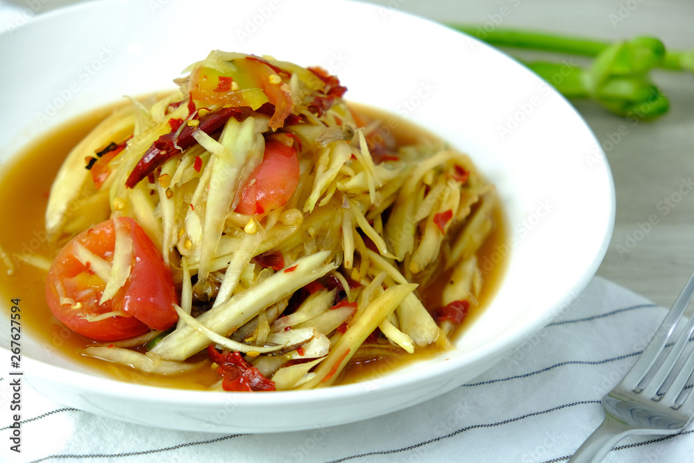 Papaya Salad with Crab. Thai food cuisine menu “Somtum”. It’s tasty, Spicy, Sour and Salty. Famous in Thailand and Lao. Close up Dish with fork on wooden background. Papaya Salad with Crab. Thai food cuisine menu “Somtum”. It’s tasty, Spicy, Sour and Salty. Famous in Thailand and Lao. Close up Dish with fork on wooden background.