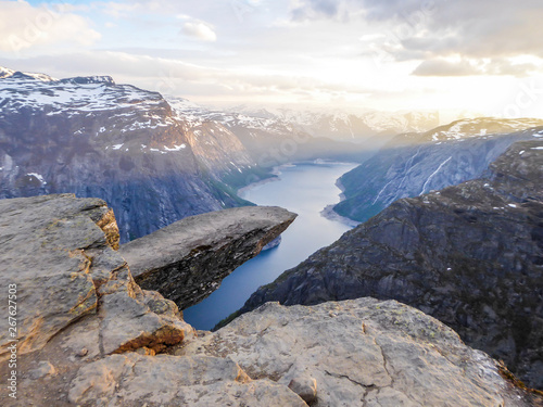 Famous Rock Formation Trolltunga With A View From The Above On Ringedalsvatnet Lake Norway Rock Hanging Slopes Of The Mountains Are Partially Covered With Snow Soft Colors Of The Sunrise Stock Photo