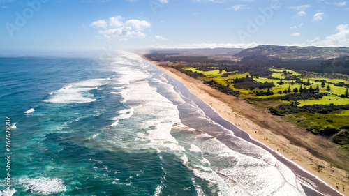 Oceanic surf on a popular beach on sunny day. Muriwai Beach, Auckland, New Zealand photo