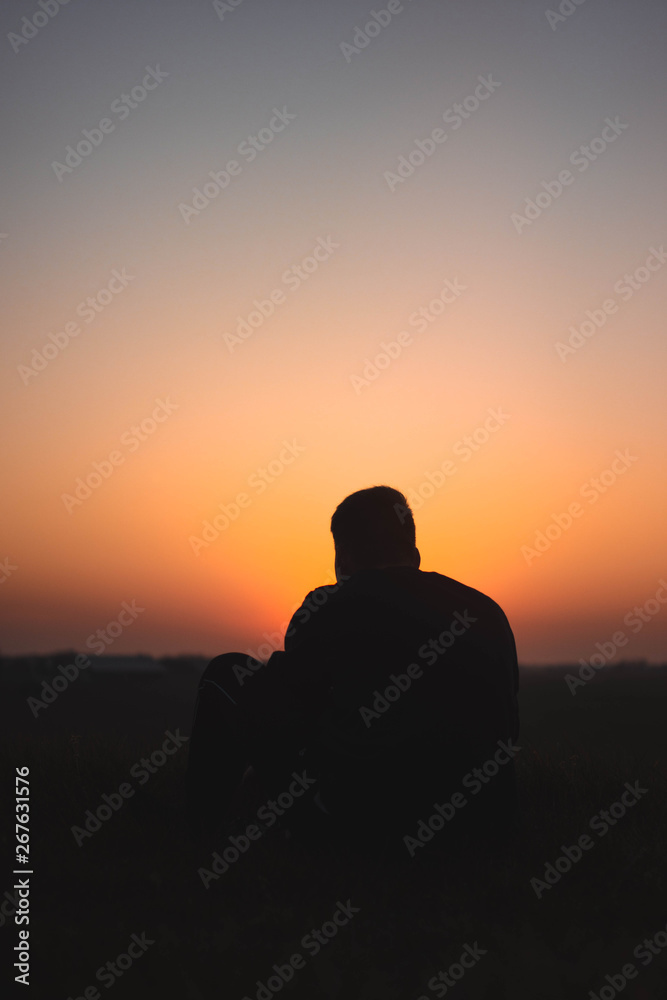 Guy sitting in front of Sunset