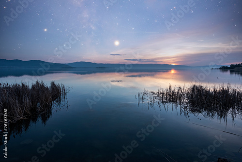 Beautiful sunrise and colorful starry sky over the lake . Armenia Sevan lake.