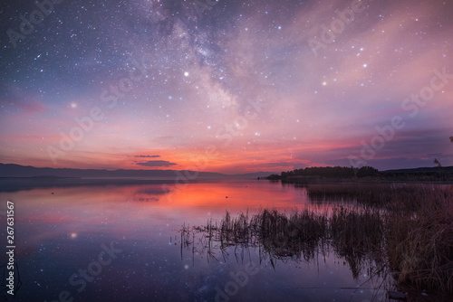 Beautiful sunrise and colorful starry sky over the lake . Armenia Sevan lake.