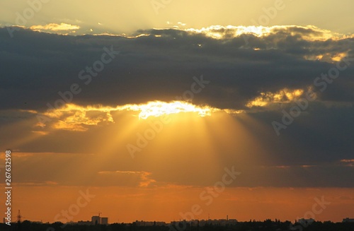 The sun rays break through the clouds at golden sunset, natural background 