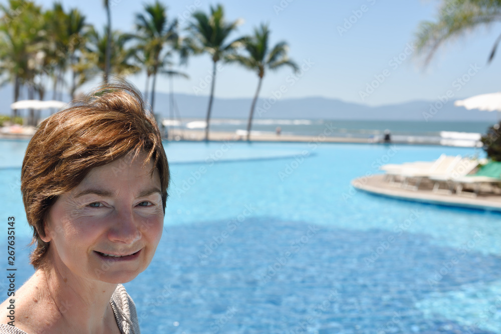 Close up of senior retired woman standing by a pool on the Pacific Ocean Nuevo Vallarta Mexico