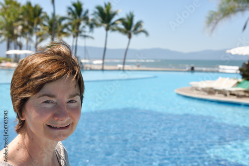 Close up of senior retired woman standing by a pool on the Pacific Ocean Nuevo Vallarta Mexico © Reimar