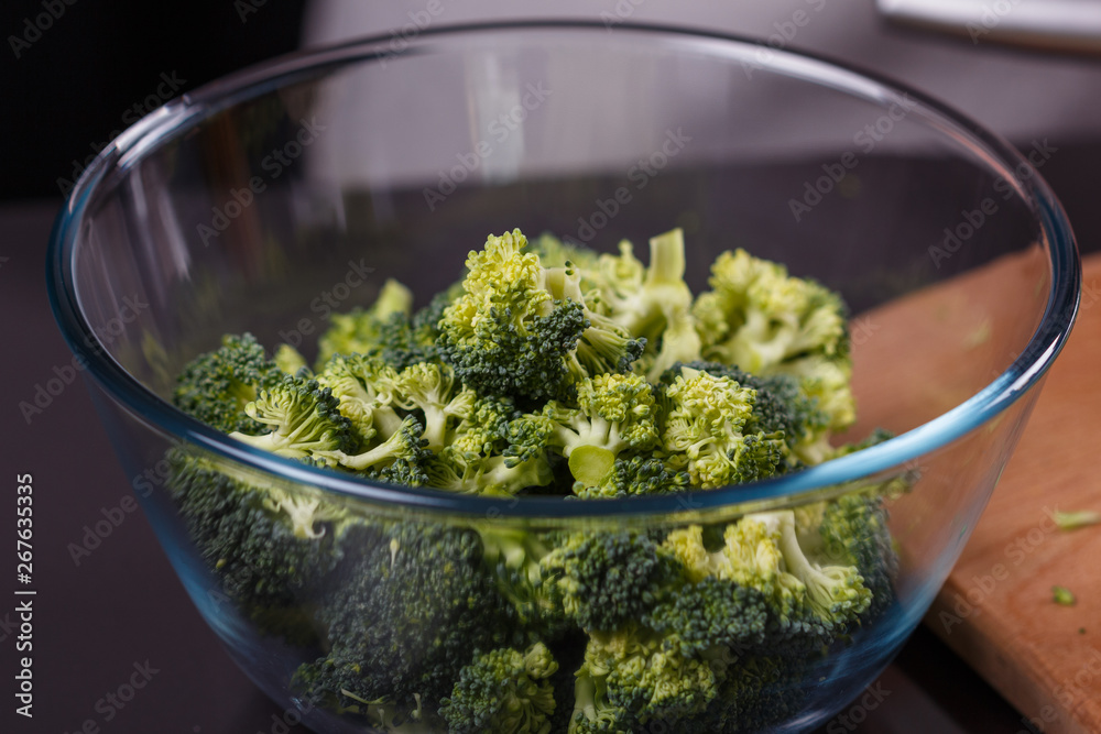 young woman in a gray apron roasts cauliflower broccoli young woman in a gray apron roasts cauliflower broccoli