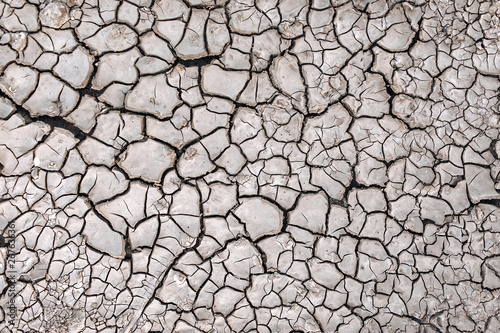 Dry cracked earth. Soil during the drought season. Background close up. The texture of the desert.