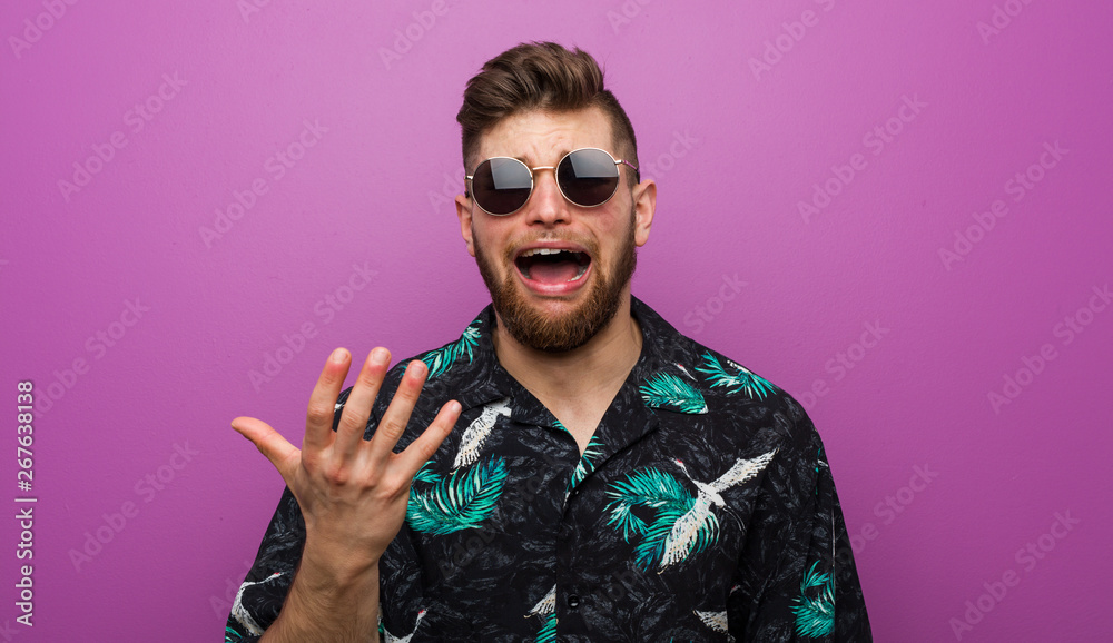 Obraz premium Young man wearing a vacation look screaming with rage.