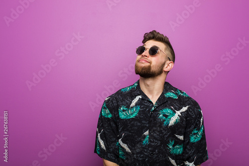 Young man wearing a vacation look dreaming of achieving goals and purposes
