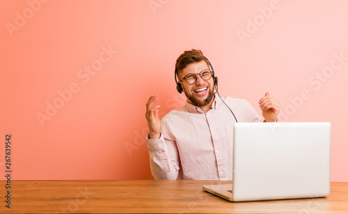 Canvas Print Young man working in a call center joyful laughing a lot