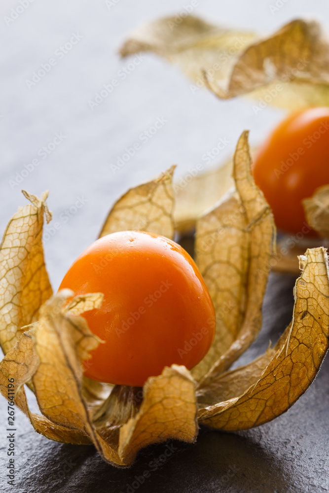 juicy winter cherry on a dark stone background juicy winter cherry on a dark stone background