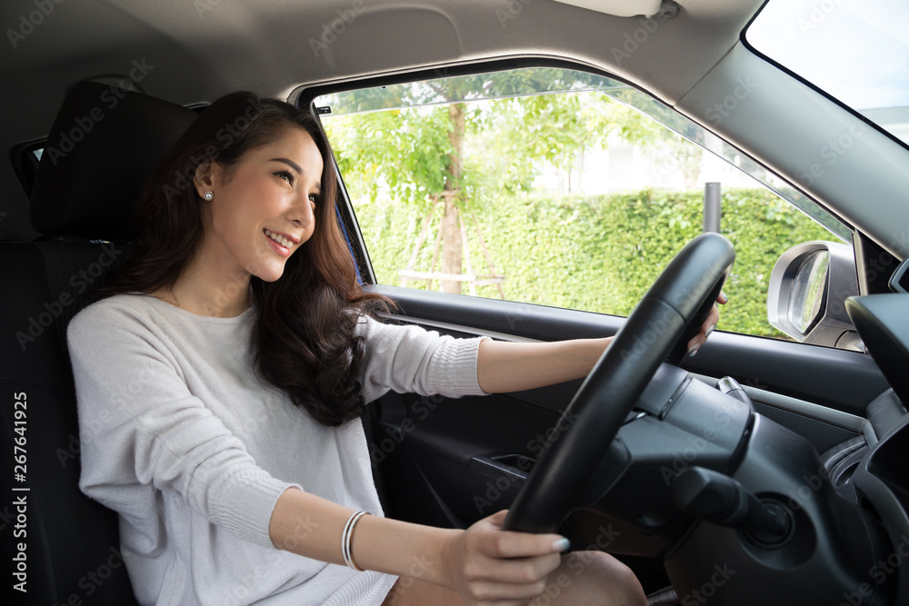 Asian women driving a car and smile happily with glad positive expression during the drive to travel journey, People enjoy laughing and relaxed happy woman on road trip vacation concept, Thai model