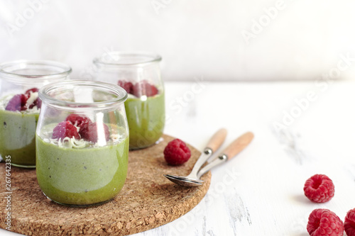 White chocolate cream mousse with matcha, avocado, pistachio, fresh raspberries - healthy vegan dairy free, gluten free