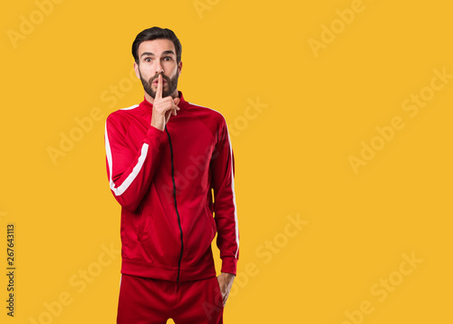 Young fitness man keeping a secret or asking for silence