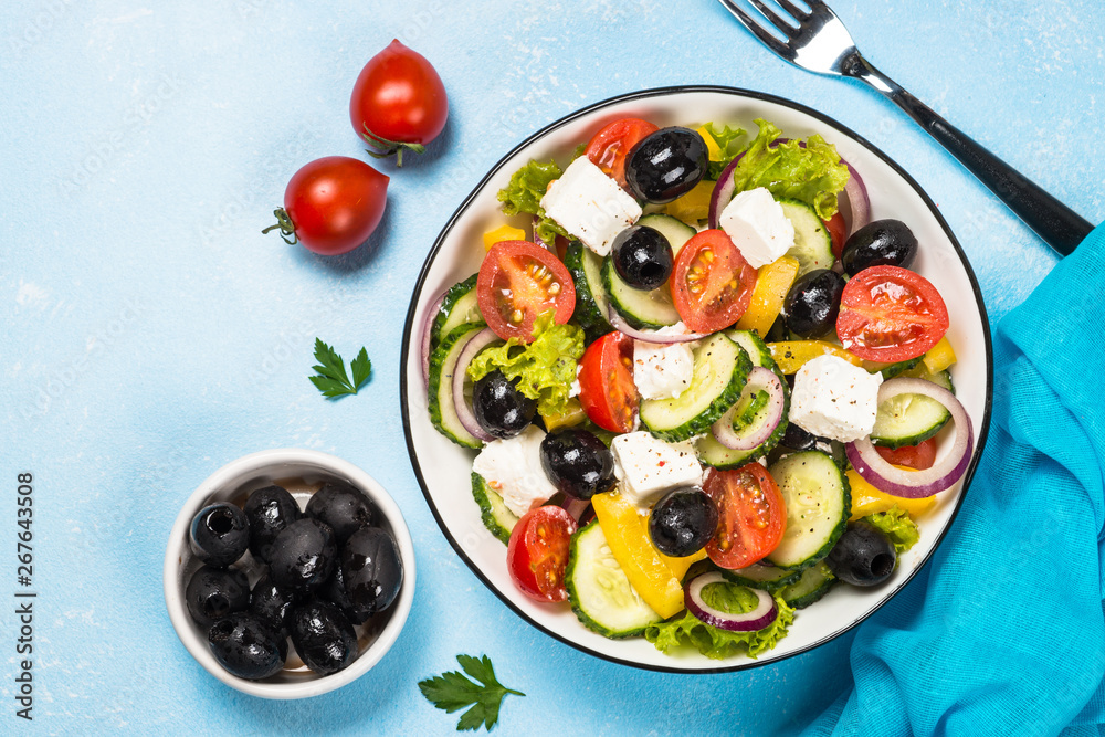 Greek salad on blue table.