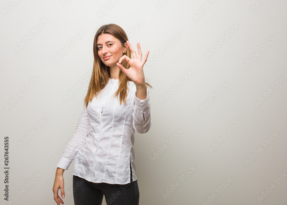 Young russian girl cheerful and confident doing ok gesture Young russian girl cheerful and confident doing ok gesture