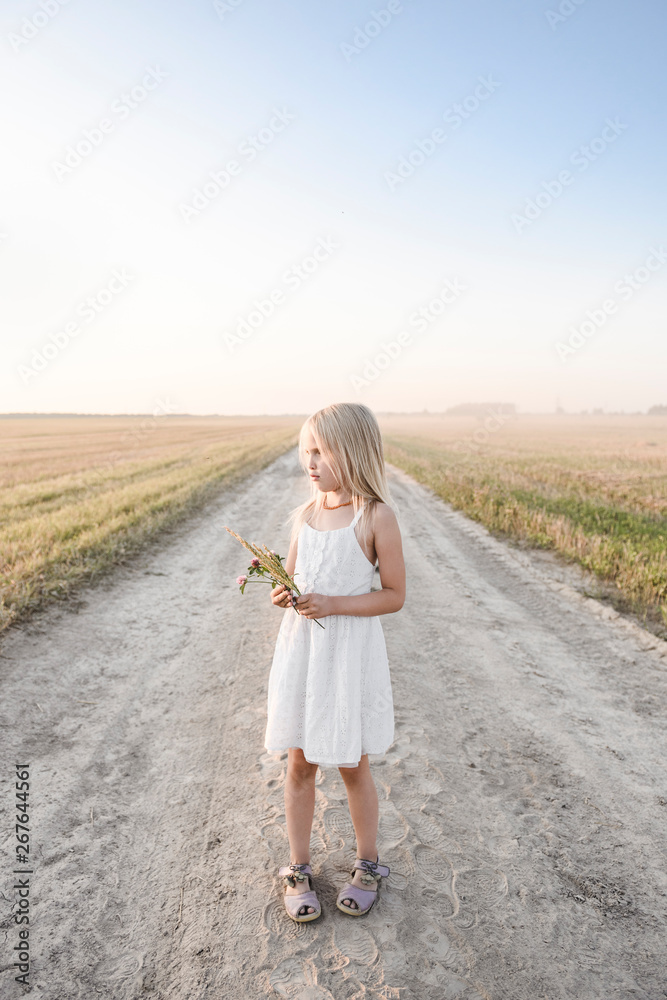 Girl standing on a rural dirt track Girl standing on a rural dirt track