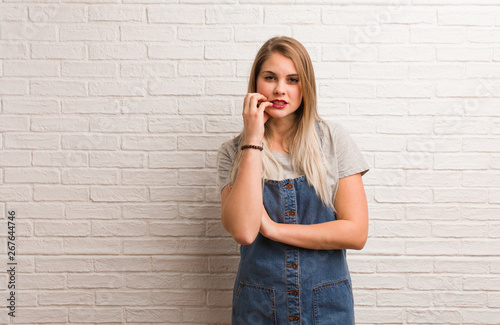 Young russian hipster woman biting nails, nervous and very anxious © Asier