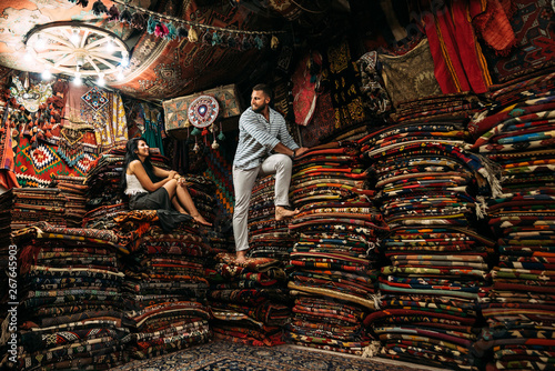 Man and a woma in the store. Couple in love in Turkey. Man and woman in the Eastern country. Gift shop. A couple in love travels. Persian shop. Tourists in store. Oriental carpet. Istanbul. Cappadocia
