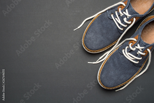 Blue denim men's casual shoes on dark background. Overhead view of men's casual outfits. Fashion and style concept, flat lay, copy space for text