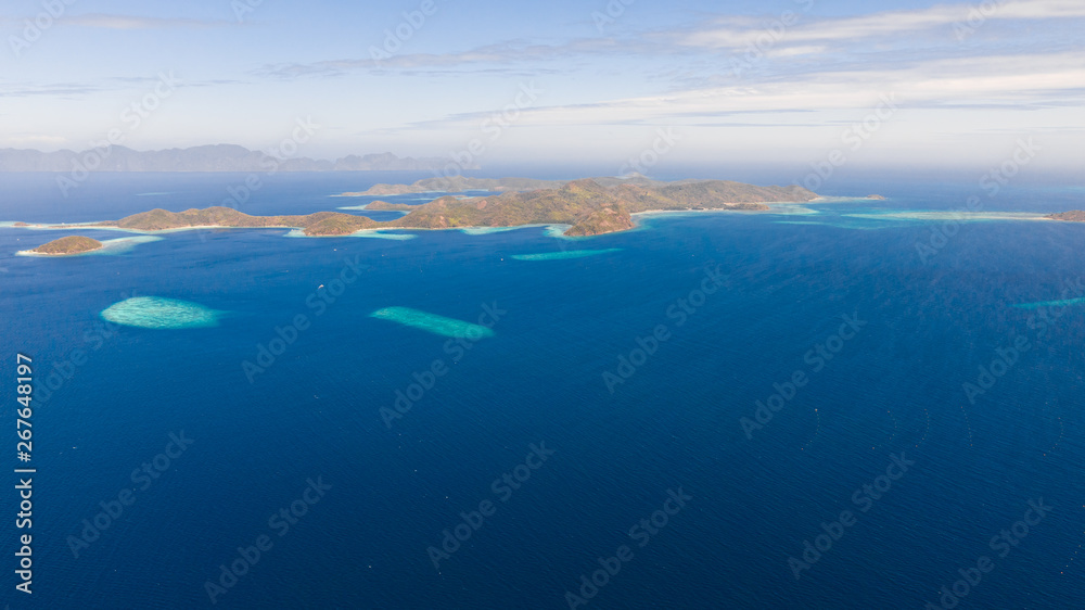 aerial view tropical islands with blue lagoon, coral reef and sandy beach. Palawan, Philippines. Islands of the Malayan archipelago with turquoise lagoons.