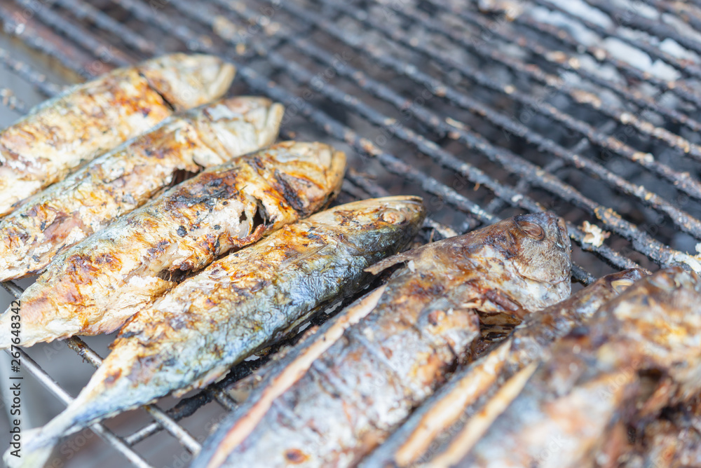 Salt-Crusted Grilled Seabass fish grill on charcoal stove for sale at Thai street food