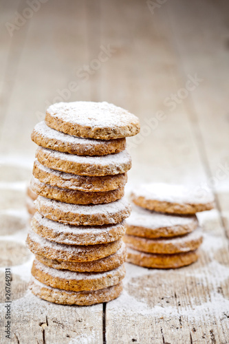 Fresh oat cookies with sugar powder closeup on rustic wooden table.