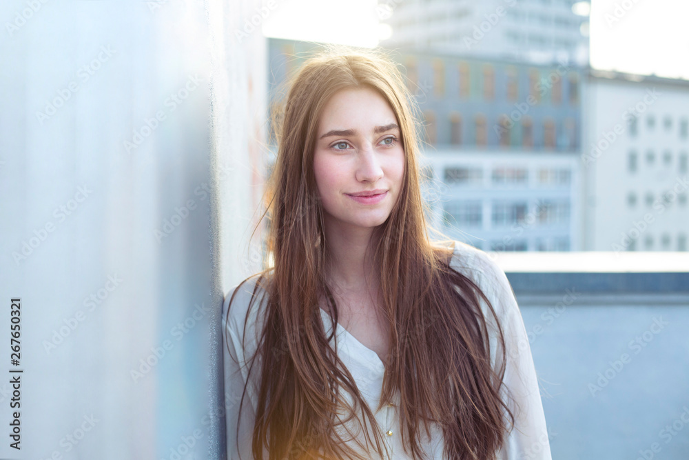 Portrait of smiling young woman leaning against a wall Portrait of smiling young woman leaning against a wall