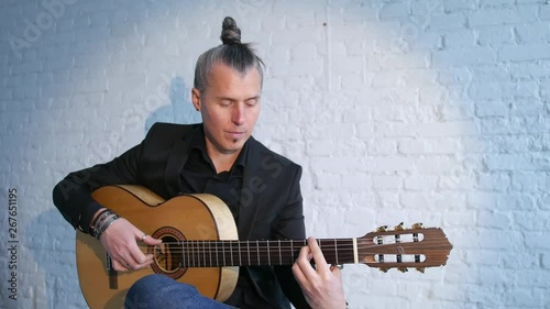 guitar player playing flamenco music on a white brick wall background