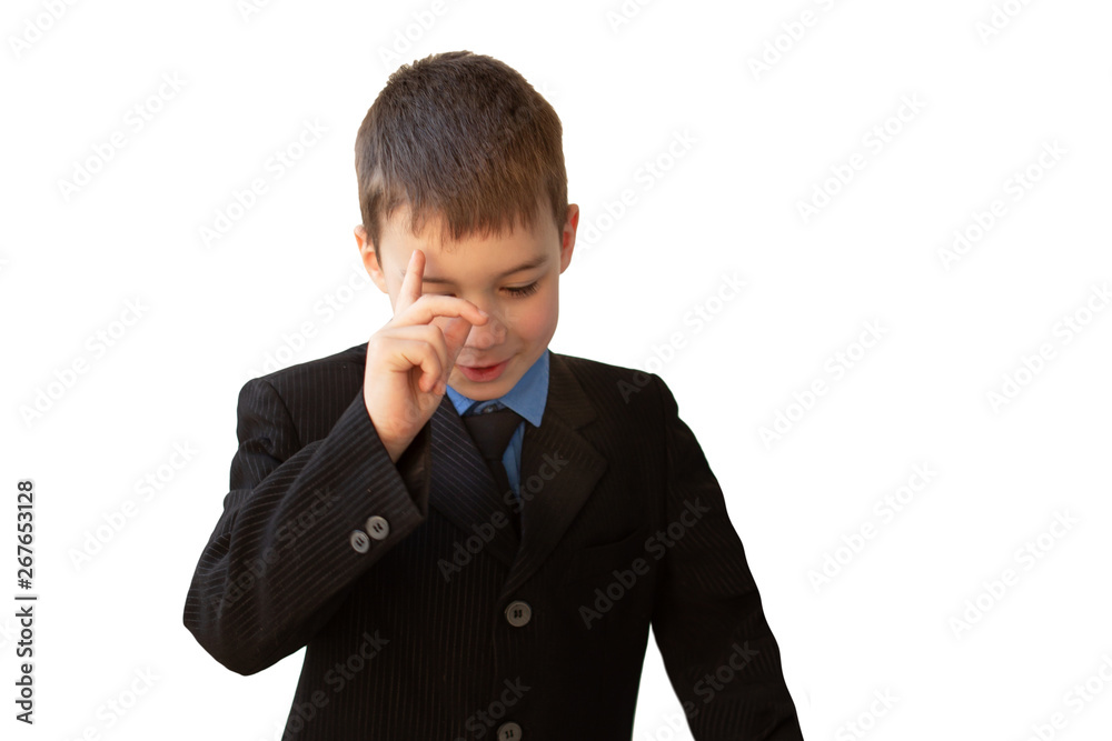 boy, schoolboy, in black business suit stands with his head down, with a smile of inspiration on his face, raising his hand to his forehead boy, schoolboy, in black business suit stands with his head down, with a smile of inspiration on his face, raising his hand to his forehead
