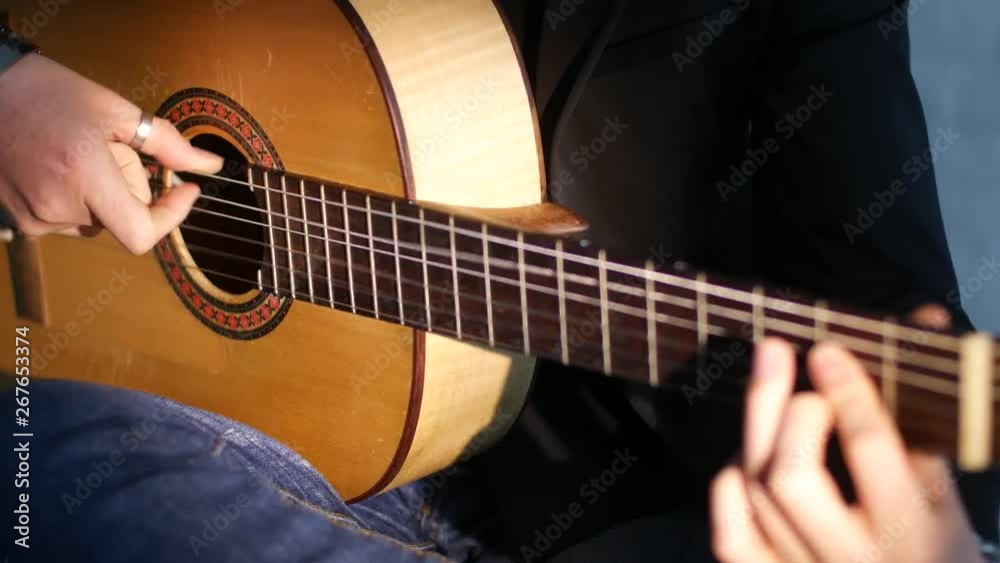 close-up of guitar strings and fingerboard, guitarist plays flamenco on acoustic guitar close-up of guitar strings and fingerboard, guitarist plays flamenco on acoustic guitar