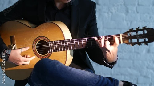 close-up of guitar strings and fingerboard, guitarist plays flamenco on acoustic guitar