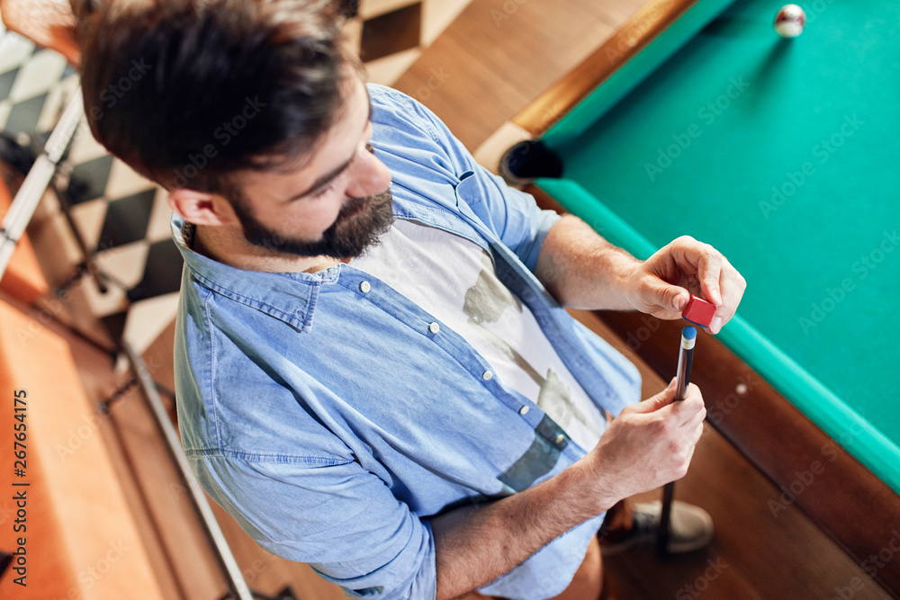 Man preparing his billiards cue Man preparing his billiards cue