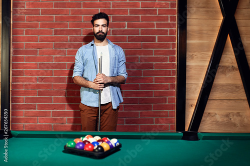 Portrait of serious man at billiard table