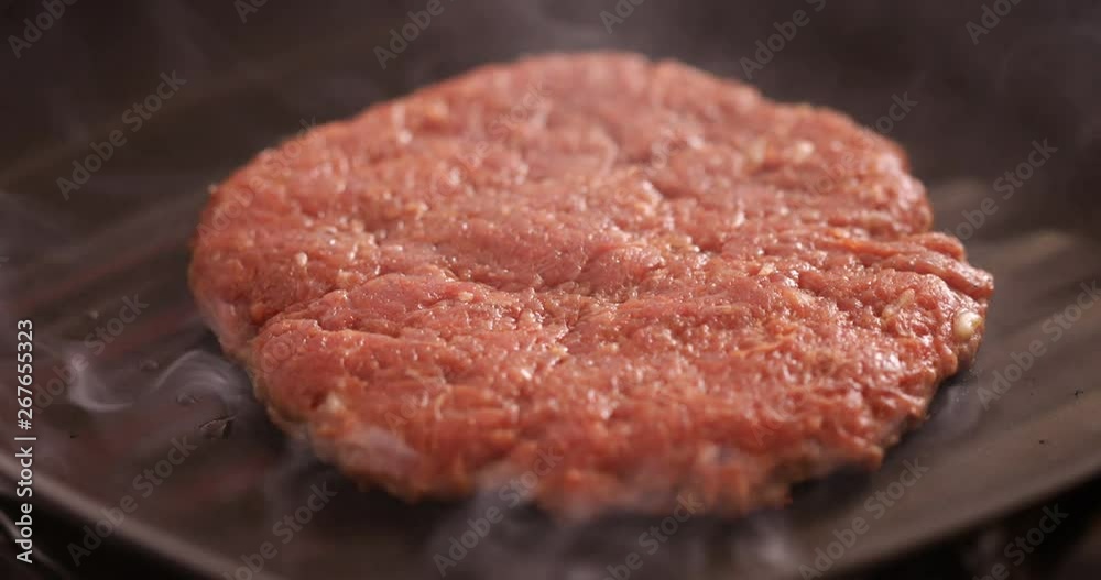 Burger making, minced steak griled at both sides at grilling pan, close-up Burger making, minced steak griled at both sides at grilling pan, close-up