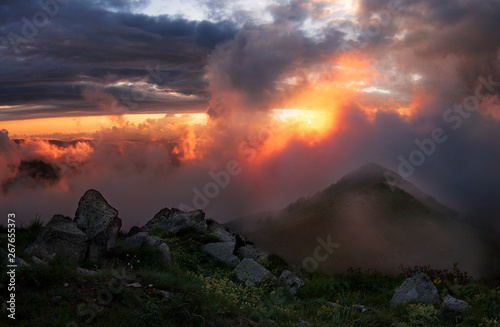 Оранжевый закат с кучевыми облаками после дождя в горах. 