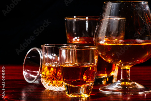 Brandy or liquor,Set of strong alcoholic drinks in glasses and shot glass on dark wood background