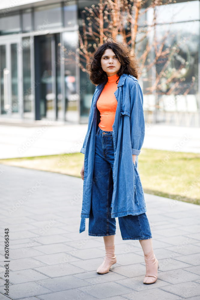 Young pretty girl walking on the street, dressed in jeans and denim shirt. Student weekdays Young pretty girl walking on the street, dressed in jeans and denim shirt. Student weekdays